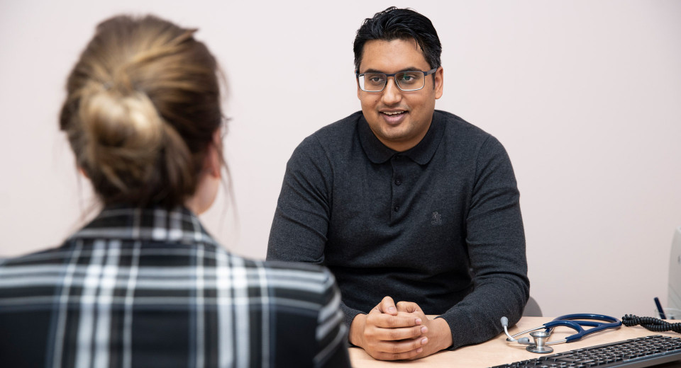 Waarnemend huisarts Imtiaas Joemai in gesprek met patiënt